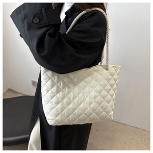 Gros plan d'un sac cabas matelassé blanc avec surpiqûres en losanges et bandoulière en corde