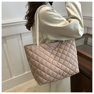 Détail latéral du sac fourre-tout matelassé champagne avec poignées en corde et œillets