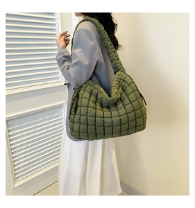 Detail van de legergroene gewatteerde cloudbag met trekkoord aan de zijkant en brede riem