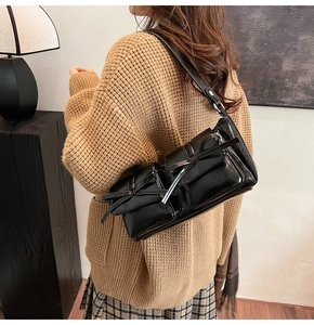 Detailansicht der schwarzen PU-Schultertasche mit Schleifentaschen aus seitlicher Perspektive