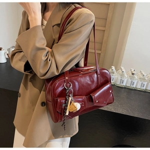 Détail du sac à épaule vintage en cuir PU bordeaux avec poches à boucle et charms sportifs
