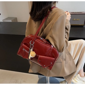 Détail du sac à bandoulière en cuir PU bordeaux brillant avec pendentif chat