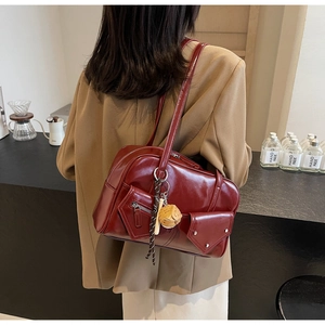 Détail du sac à main en cuir PU brillant bordeaux avec fermeture éclair et breloque