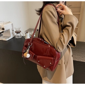 Détail du sac à main en cuir PU bordeaux avec breloque baseball et poches à boucles