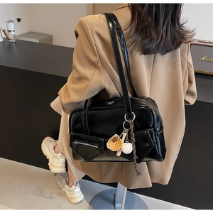 Détail du sac à main en cuir PU noir brillant avec breloques de baseball et poche zippée