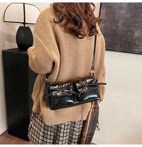 Retro black PU leather underarm bag with bow-knot pockets styled on a model's shoulder
