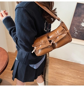 Detail der karamellbraunen PU-Schultertasche mit dekorativen Schleifen und Retro-Taschen