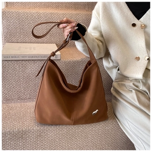 Detail of a brown Hobo shoulder bag featuring a unique silver metallic accent on the side