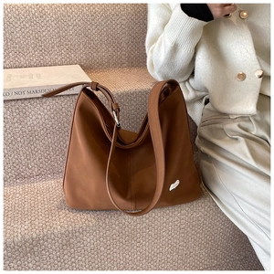 Detailed close-up of a caramel brown hobo bag in soft matte PU leather with silver hardware