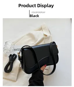 Detail view of black leather flap crossbody bag with gold hardware for office look