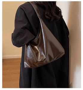 Détail d'un grand sac cabas en cuir PU marron foncé brillant avec finition vintage usée