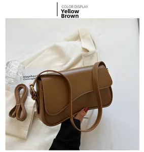 Detail view of yellow brown PU leather shoulder bag with asymmetrical flap and gold metal ring