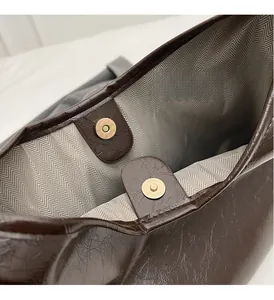 Détail du sac cabas marron foncé avec texture cuir huilé et fermoirs aimantés dorés