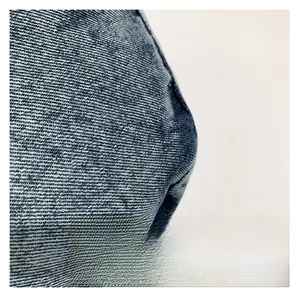 Gros plan détaillé sur le tissu denim bleu foncé délavé et la texture sergée du sac à main