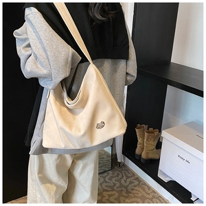 Detail shot of a beige PU leather crossbody bag featuring an elegant metal buckle detail