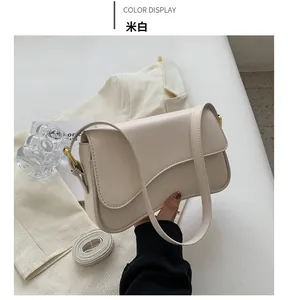 Detailed view of cream white leather crossbody bag with dual straps and gold hardware