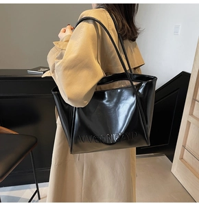Vista dettagliata della borsa tote in pelle verniciata nera con logo in rilievo