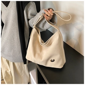 Detailed view of the soft beige PU leather texture and silver bean metal buckle on the hobo bag