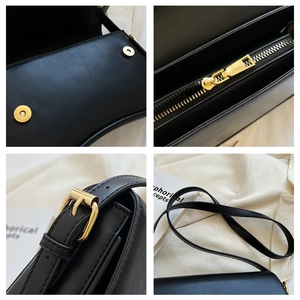 Close-up of golden magnetic buckle and adjustable strap hardware on black leather bag