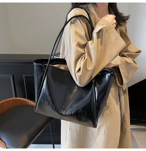 Dettaglio borsa tote nera lucida con logo in rilievo e doppi spallacci resistenti