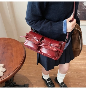 Detail view of burgundy PU shoulder bag featuring dual bow pockets and retro glossy finish
