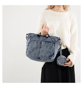 Détail du grand sac fourre-tout en jean délavé avec poches et petit porte-monnaie