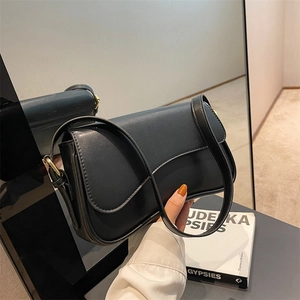 Minimalist black leather crossbody bag with unique wavy flap and golden buckle detail