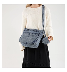 Détail d'un sac bandoulière en denim délavé vintage avec un mini porte-monnaie amovible