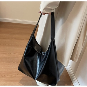 Détail du grand sac cabas noir avec texture plissée sur une surface en similicuir de qualité