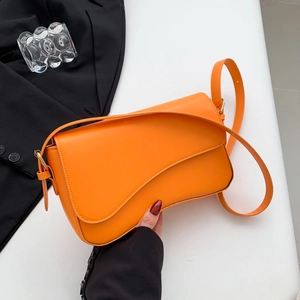 Modern orange leather underarm bag with asymmetric flap and golden metal hardware