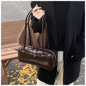 Dark brown patent leather shoulder bag detail with glossy finish and silver zipper closure