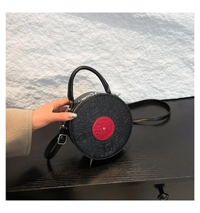 Close-up of black PU leather record bag with red center and embossed face texture