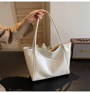 Dettaglio che mostra la grande capacità della borsa tote color crema con cinque bottiglie