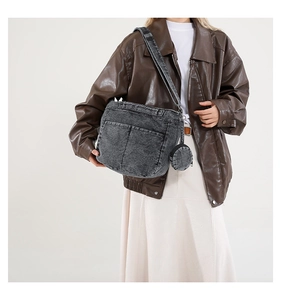 Détail d'un sac à bandoulière en denim gris délavé avec pochette ronde et sangle rétro