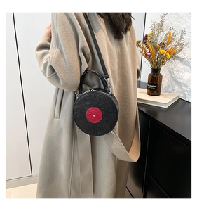 Close-up of black PU leather record bag with red center and embossed cartoon motifs