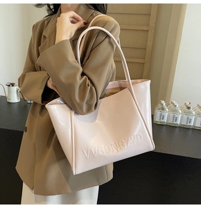 Dettaglio della borsa tote rosa con logo VVGONGZYD a rilievo e texture lucida