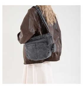Détail du cabas en denim gris montrant les poches et le pendentif porte-monnaie assorti