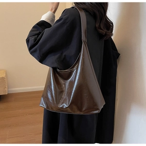 Détails d'un grand sac hobo marron foncé avec une finition brillante en cuir ciré