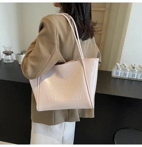 Grande borsa shopper crema e rosa con manici lunghi indossata da una modella