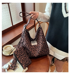 Detail of leopard print hobo bag and matching zip pouch on a cozy wooden cafe table