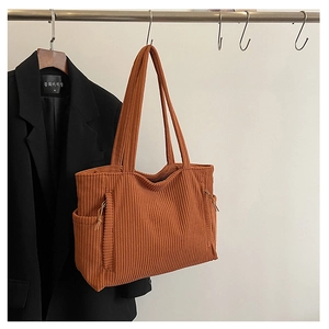 Detail der orangefarbenen Cord-Tasche mit Seitentaschen und dekorativen Kordelzügen