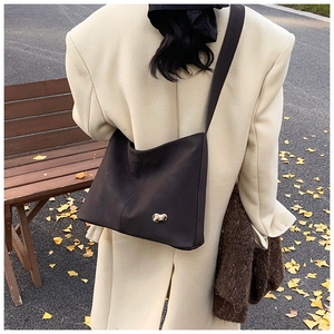 Deep brown PU leather crossbody bag with metallic studs styled with an autumn coat