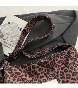 Detail of the leopard print tote bag with wide shoulder strap on a black blazer