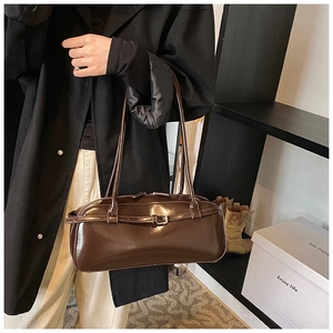 Detail of dark brown glossy shoulder bag with vintage buckle strap and shiny finish