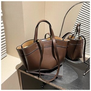 Brown tote bag with wavy edges and contrast stitching shown in a stylish room setting