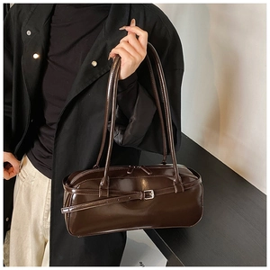 Detailed close-up of dark brown glossy rectangular shoulder bag with metal buckle and dual zips
