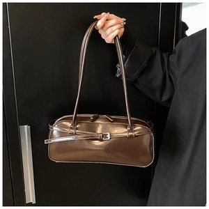 Macro view of dark coffee glossy patent leather shoulder bag with buckle details