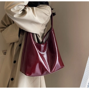 Détail du sac cabas bordeaux en cuir verni brillant avec texture plissée et anse chic