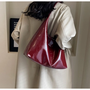 Détail de la texture cuir verni bordeaux et bandoulière du grand sac à main vintage