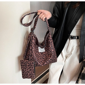 Detail view of leopard print canvas tote bag with matching zipper pouch and Muhell tag